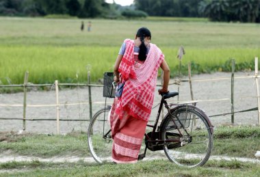 Bisikletin yanında duran kadın, Bongaigaon, Assam, Hindistan 