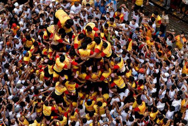 Dadar 'da Dahikala Festivali' nde insan piramidi oluşturan sarı beyaz üniformalı Govinda Bombay; Maharashtra; Hindistan