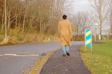Paltolu yaşlı kadın sokakta tek başına yürüyor.