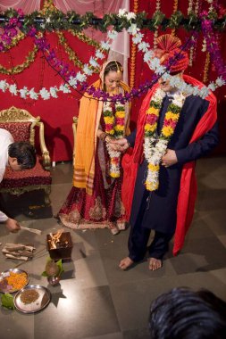 Hintli gelin ve damat kutsal ateşin etrafında el ele tutuşuyorlar. 