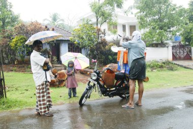Yağmurlu bir günde balık satıcısı; Kerala; Hindistan