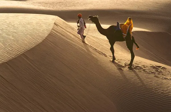 stock image Desert trekkers rajasthani man and woman walking with camel, Rajasthan, India 
