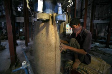 Sangli, Maharashtra, Hindistan 'daki şeker fabrikasında şeker dolduran bir işçi. 