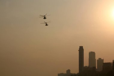 Two helicopters performing at the Aerobatics show which was conducted by Sagar Pawan team of the Fly-In at Girgaum Chowpatty, Bombay Mumbai, Maharashtra, India  clipart
