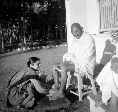 A co-ashramite washing Mahatma Gandhis feet at Bardoli, Gujarat, India, 1939   clipart