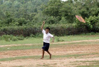 Uçurtma uçuran kırsal çocuk, Ngo Patang, Sambalpur, Orissa, Hindistan 