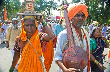 Ektara ve Tulsi bitkileriyle sadık bir çift Vitthala tapınağına, Pandharpur panayırına, Pandharpur 'a, Maharashtra' ya, Hindistan 'a doğru yürüyor.
