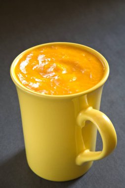 mango pulp served in mug on black  background clipart