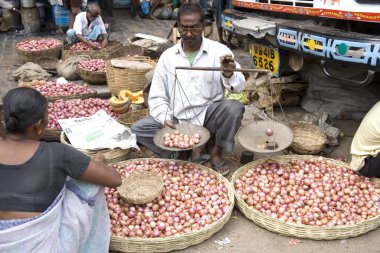 Erkekler, kilolarını kilo olarak ölçerek kadına sebze pazarında, Siyaldah, Kalküta 'da, şimdi Kolkata, Batı Bengal, Hindistan' da satıyorlar.