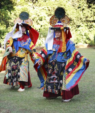 Gündüz vakti caddede renkli Tibetli dansçılar