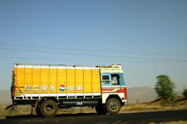 Sanayi, ulaşım, mavi gökyüzüne doğru giden sarı kamyon, 3 numaralı Mumbai Bombay Nasik Yolu, Maharashtra, Hindistan 