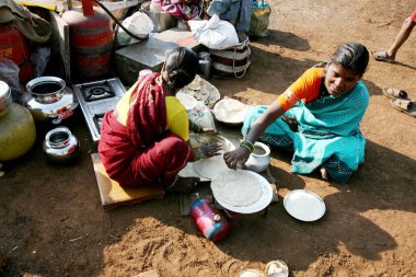 Hindistan, Maharashtra 'da Sangli köyünde çalışan erkekler için rotis yapan kadınlar. 