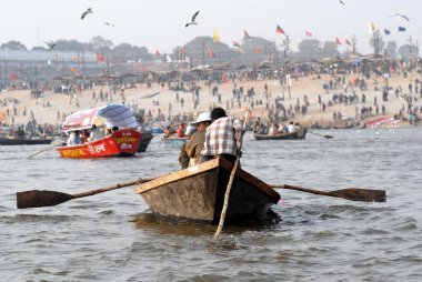 Devotees sit in boat arriving at confluence of Ganges; Yamuna and Saraswati rivers to take holy dip during Ardh Kumbh Mela, Allahabad, Uttar Pradesh; India  clipart