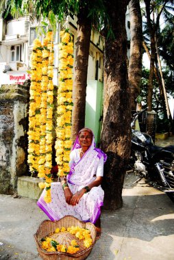 Diwali Festivali 'nde çiçek çelengi satan kadın.