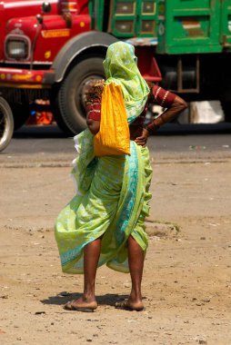 Urli Kanchan; Pune; Maharashtra; Hindistan 'da otobüs bekleyen 9 yarda sari giyen yaşlı kadın.