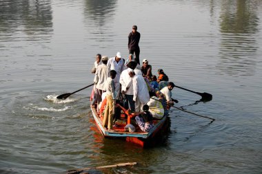 Haripur köyü halkı Sangli, Maharashtra ve Hindistan 'da Krishna nehrini geçmek için bir tekne kullanıyor.