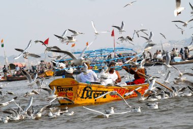 Takipçiler Ganj kavşağına ulaşan teknede oturuyorlar; Ardh Kumbh Mela, Allahabad, Uttar Pradesh; Hindistan;  