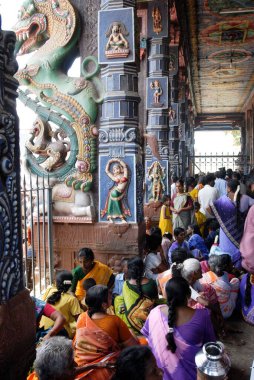 Subrahmanya Swami Tapınağı, Tirupparankundram, Tamil Nadu, Hindistan 'daki sütunlu salonun önünde oturanlar 