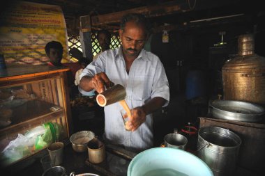 Thanjavur, Tamil Nadu, Hindistan 'daki çay dükkanına çay döken adam.   