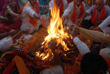 Several people performing Havan sitting around fire Jodhpur Rajasthan India  clipart