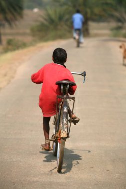 Çocuk Jharkhand, Hindistan 'da bisiklet sürüyor. 