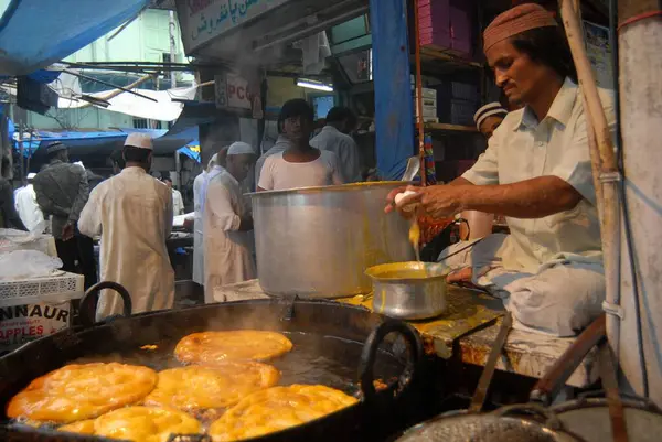 Bir gıda tedarikçisi, Müslümanlar Pydhonie, Bombay 'daki Khatri Mescidi' nde ramazan orucunu kırarken yenilebilir yiyecekler hazırlıyor. Mumbai, Maharashtra, Hindistan 