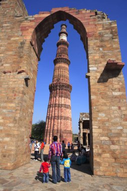 Baba ve oğulları Kutub Minar 'ı 1311 kırmızı kumtaşı kulesinden, Hint-Müslüman sanatı, Delhi sultanlığı, Delhi, Hindistan UNESCO Dünya Mirası Sitesinden izliyor.