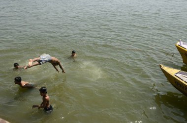 Çocuklar Uttar, Pradesh, Hindistan 'daki Varanasi Ghat' ta Ganga nehrinde yıkanıyorlar.