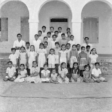 Hindistan 'da 1900' lü yılların siyah-beyaz Hint okul çocuklarının öğretmenler grubu fotoğrafı.  