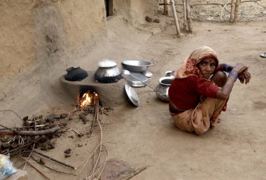 Kırsal kesimdeki kadın açık mutfakta oturuyor, Rajouli, Nawada, Bihar, Hindistan 