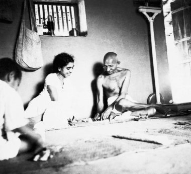 Mahatma Gandhi, Sushila Nayar ve diğerleriyle birlikte Sevagram Ashram 'daki kulübesinde oturuyor, 1937   