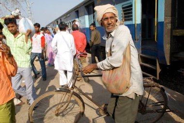 Arka planda bisiklet treni olan yolcu; Manikpur istasyonu; Uttar Pradesh; Hindistan