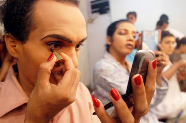 Erkek sanatçı göz kalemi kullanıyor. Bin Baicha Tamasha, Hindistan gösterisine hazırlanıyor. 