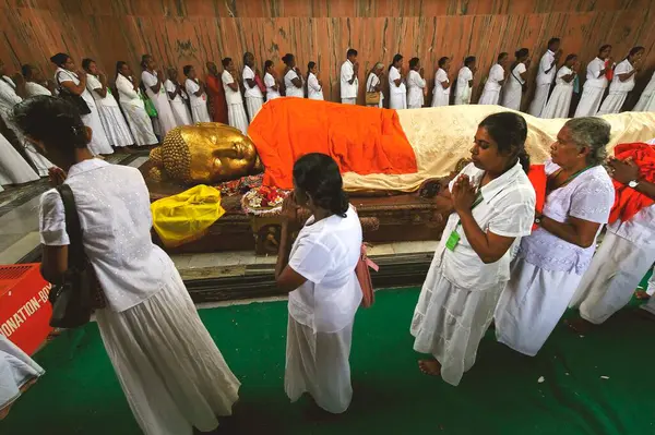 stock image Devotees offering pray ; statue of Lord Buddhas nirwan Mahaparinirvan ; Buddhist site ; Kushinagar ; Uttar Pradesh ; India 