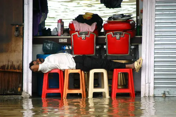 stock image Barber sleep in flooded shop caused due to heavy rain in Bombay Mumbai, Maharashtra, India 