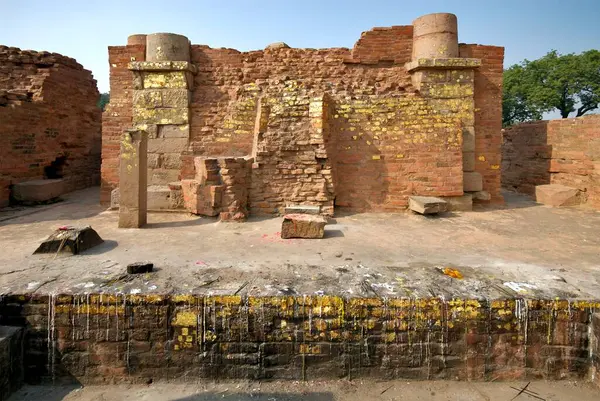 Erimiş mum ve altın yapraklar Dhamekh stupa; Sarnath; Varanasi; Uttar Pradesh; Hindistan yakınlarındaki harabe manastırların duvarlarına yapıştırılmış.