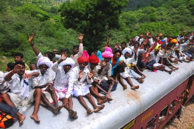 İnsanlar trenin çatısında seyahat ederken risk alıyorlar, Goram ghat, Marwar Junction, Rajasthan, Hindistan  
