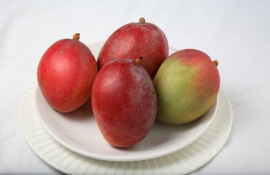 Kırmızı mangolar tabakta servis edilir, yakın plan görünüm