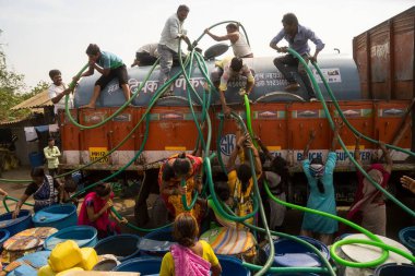 İnsanlar su tankerinden, Bhiwandi 'den, Maharashtra' dan, Hindistan 'dan plastik varillere su dolduruyorlar. 