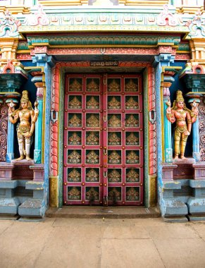Richly decorated and painted wooden door of ranganathaswamy temple at srirangam near Tiruchirappalli , Tamil Nadu , India clipart