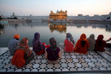 Harmandir Sahib veya Darbar Sahib 'de oturan yabancı kadın turist grubu veya Amritsar, Punjab, Hindistan' daki Altın Tapınak 