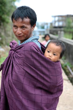 Khasi tribal man carrying his child on back, Cherrapunjee, Sohra, Meghalaya, India    clipart
