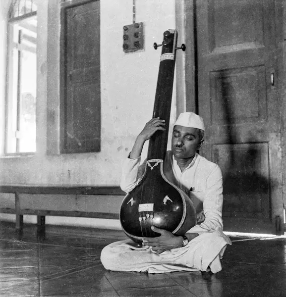 Hindistan 'da 1900' lü yılların modası, Hintli bir adamın müzikal enstalasyon tampurası çalarkenki siyah beyaz fotoğrafı 1940 'ların