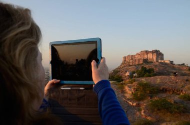 Yabancı kadın, Jodhpur Rajasthan 'daki Marwar Festivali' nde Tablet 'te manzara yakalıyor.
