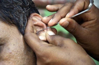 Kulak temizleyici Mumbai Maharashtra Hindistan 'da bir insanın kulağını temizliyor. 