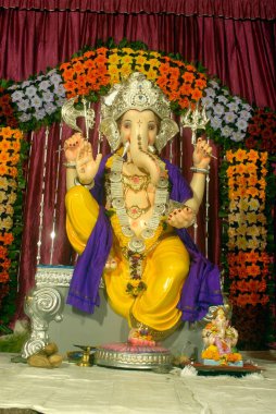 Ganesh 'in renkli putu, suni çiçeklerle süslenmiş, Ganapati festivaline tapan, Hindu fil tanrısı Pune, Maharashtra, Hindistan.