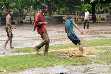 Muson yağmurlarında futbol oynayan çocuklar; beş bahçe; Bombay Mumbai; Maharashtra; Hindistan