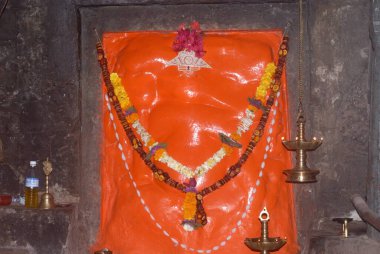 Idol of Lord Ganesh in scarlet color ; Shri Girijatmaj in Ganesh caves on mountain at Lenyadri ; Ashtavinayak ; Taluka Junnar ; District Pune ; Maharashtra ; India clipart