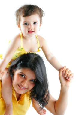 Anne ve Çocuk 1,5 yaşında bir kız çocuğu annesinin omuzlarında eğleniyor.