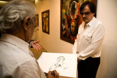 Bollywood oyuncusu Sanjay Khan ve sanatçı Sanjay Kumar çizimlerini Kala Ghoda sanat şovunda yapıyorlar, Bombay, Mumbai, Maharashtra, Hindistan  